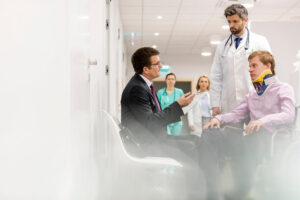 Injured patient in a wheelchair talking to his doctor and lawyer.