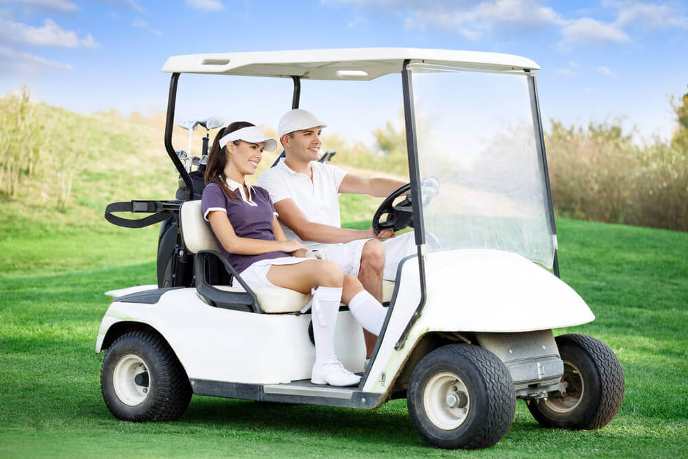 Couple riding a golf cart.