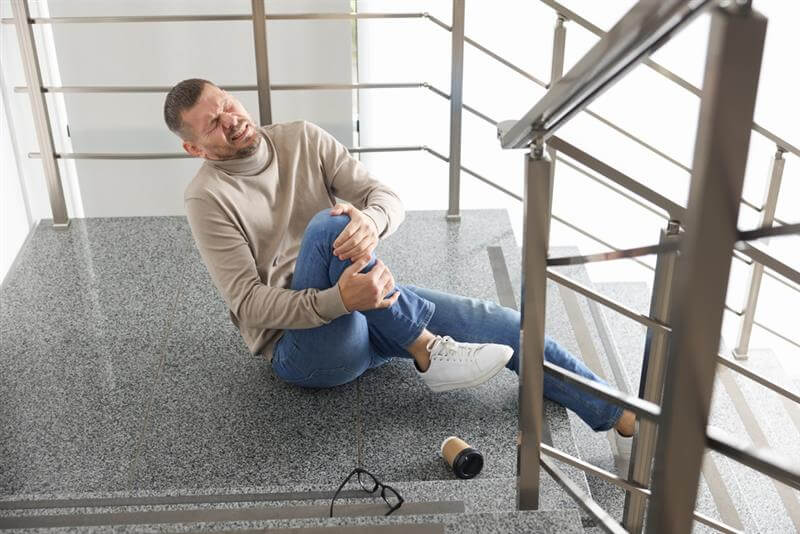Man feeling pain from injury in slip and fall.
